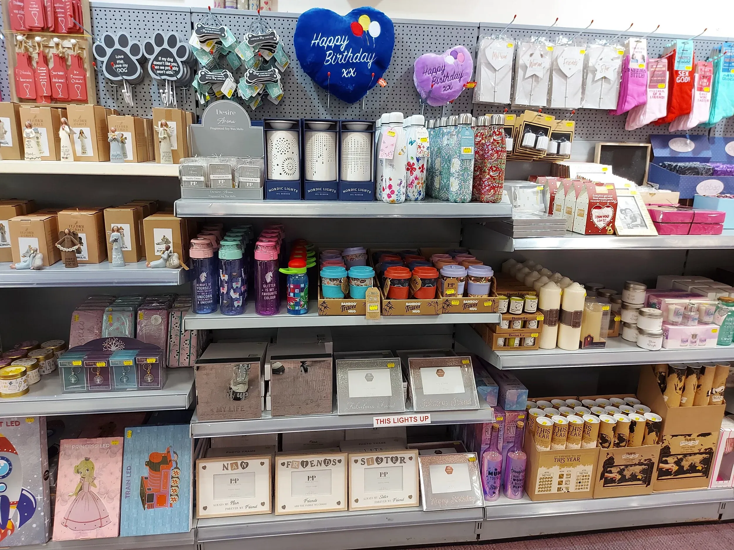Shelves of mugs, candles, gift bags and boxed gifts inside the shop